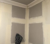 The fireplace is gone, walls replastered and cornice installed, ready for painting