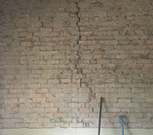 Extensive cracking in a brick wall with render removed